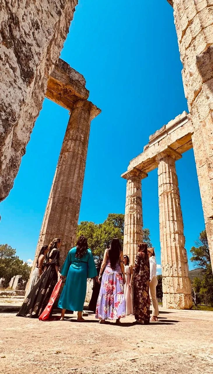A circle standing together inside the Temple of Zeus at Nemea