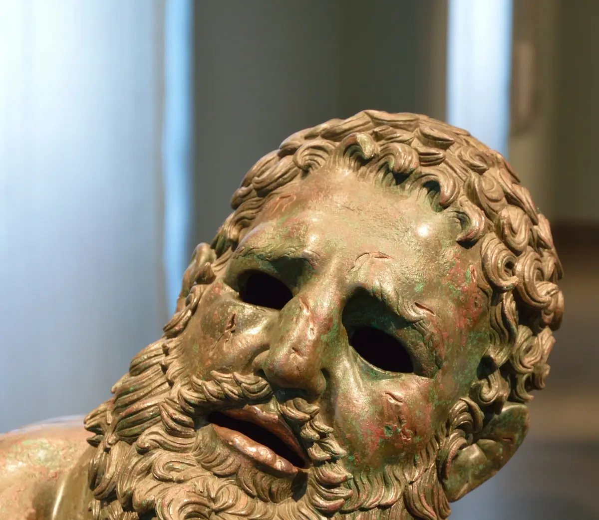 The bronze Boxer at Rest, his face marked by the fight